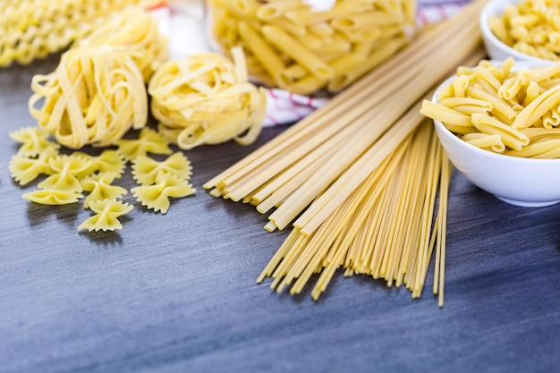 Variedad de pasta seca orgánica sobre tablero de madera.