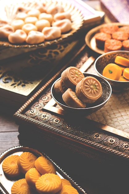 Variedad de Peda o Pedha Servido en un cuenco o plato sobre fondo blanco o con montón de regalos. Es una comida festiva popular de la India. enfoque selectivo