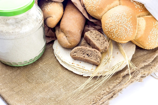 Una variedad de productos de panadería y espiguillas de trigo en un primer plano de fondo blanco