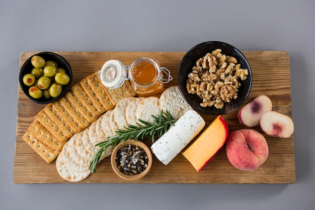 Variedad de quesos con aceitunas, durazno, miel, romero, nueces y galletas.