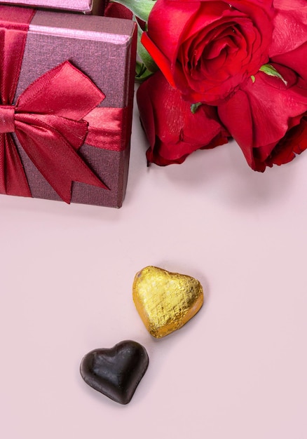 Variedad de regalos y chocolates en forma de corazón dorado aislado fondo rosa concepto de San Valentín