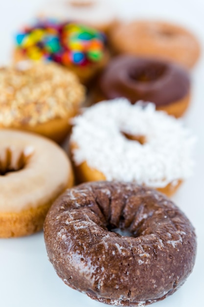 Variedad de rosquillas frescas sobre un fondo blanco.