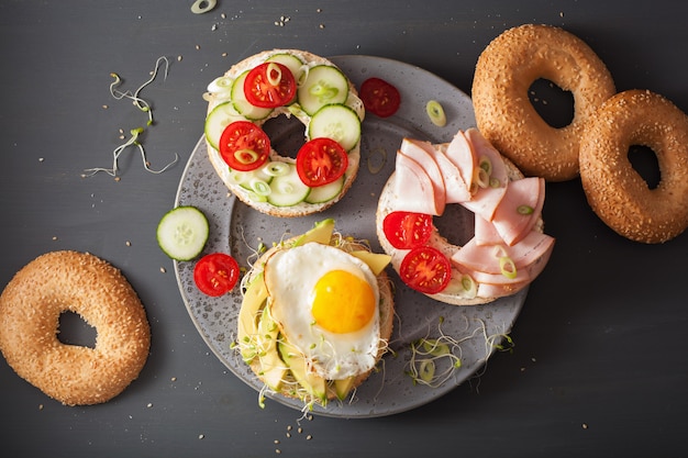 Variedad de sándwiches en bagels: huevo, aguacate, jamón, tomate, queso blando, brotes de alfalfa