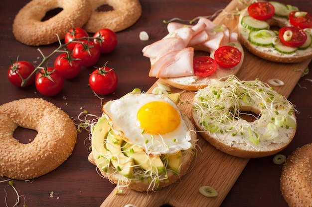 Variedad de sándwiches en bagels con huevo y verduras.