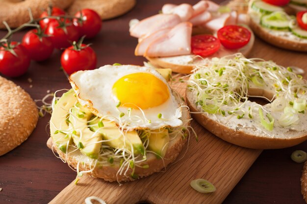 Variedad de sándwiches en bagels con huevo y verduras.