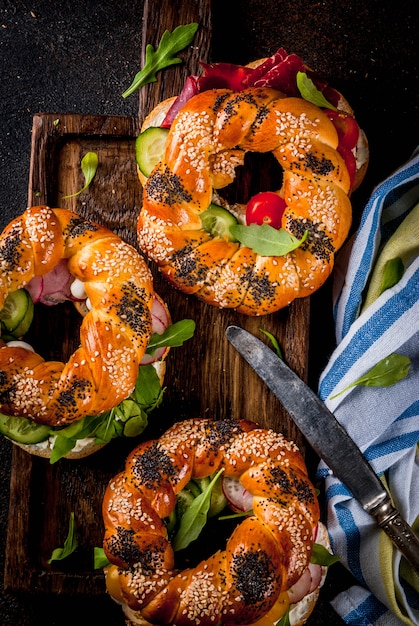 Variedad de sándwiches caseros de bagels con carne y verduras.