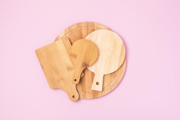 Variedad de tabla de cortar de madera circular multifuncional para cortar o servir fondo rosa