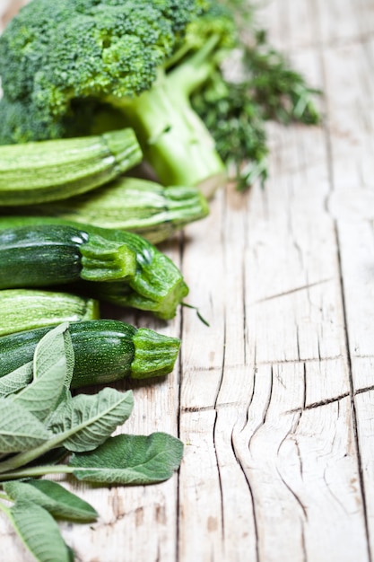 Foto variedad de verduras orgánicas verdes en fondo de madera rústico.