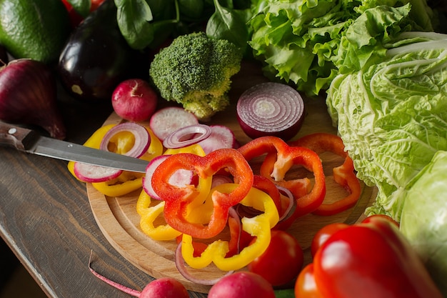 Variedad de verduras y pimientos picados y cebollas rojas en un concepto de cocina de placa