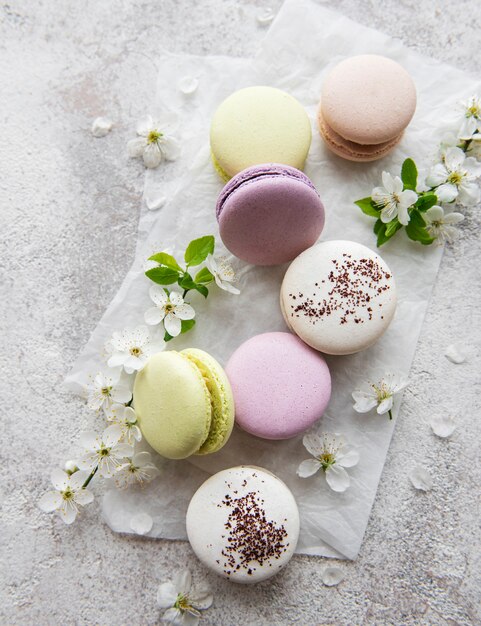 Variedade colorida de macaroons doces franceses em um fundo cinza têxtil