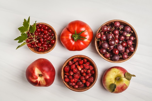 Variedade de alimentos vermelhos em um fundo branco, vista superior. Frutas e vegetais contendo licopeno.