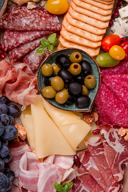 Variedade de aperitivos, salsicha e queijo em uma tábua de madeira vista superior sem pessoas