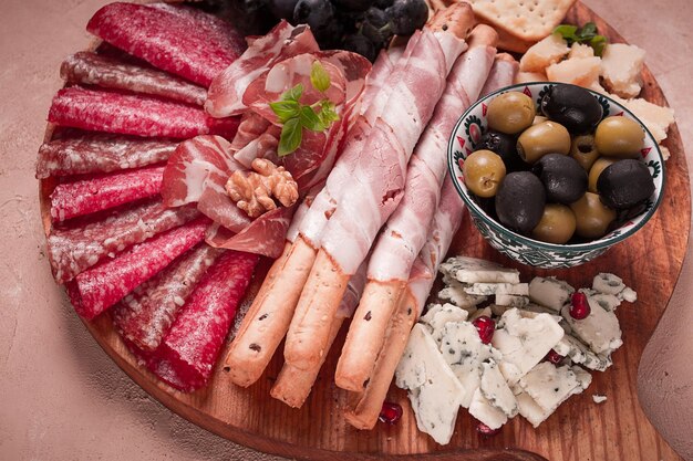 Variedade de aperitivos, salsicha e queijo em uma tábua de madeira vista superior sem pessoas