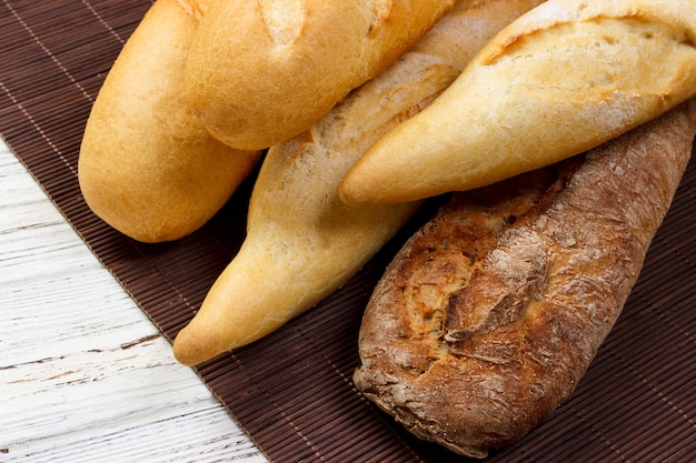 Variedade de baguetes francesas frescas sobre uma mesa de madeira