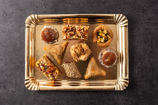 Variedade de baklava de sobremesa do ramadã na mesa de ardósia preta