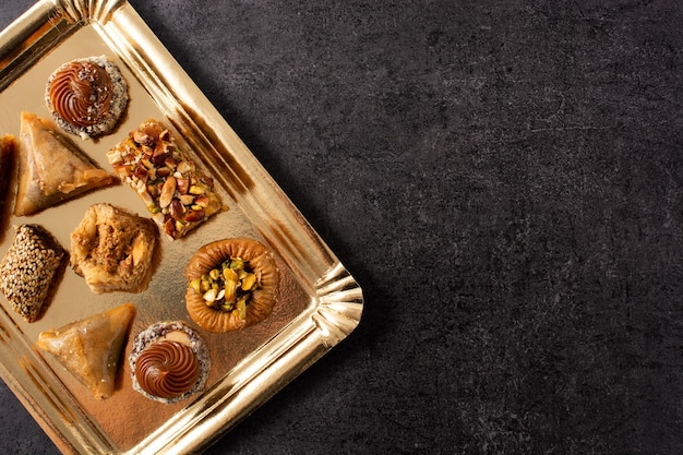 Variedade de baklava de sobremesa do Ramadã na mesa de ardósia preta