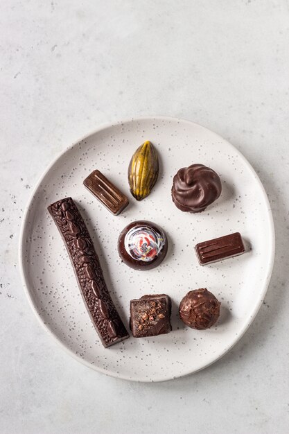 Variedade de bombons de chocolate bem em um prato de cerâmica.