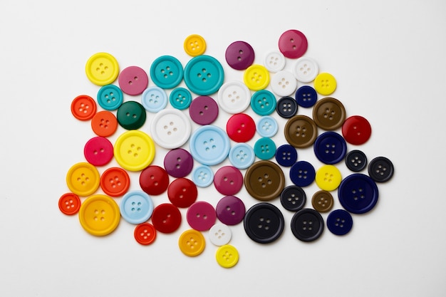 Foto variedade de botões coloridos na superfície branca