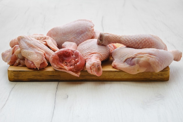 Variedade de carne de frango fresca em uma tábua de madeira