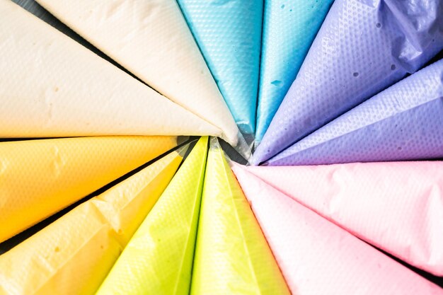 Variedade de cores de glacê real em sacos plásticos de confeitar.