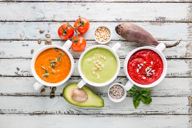 Variedade de diferentes sopas de creme de vegetais coloridas em uma tigela, vista superior. Conceito de alimentação saudável ou vegetariana.