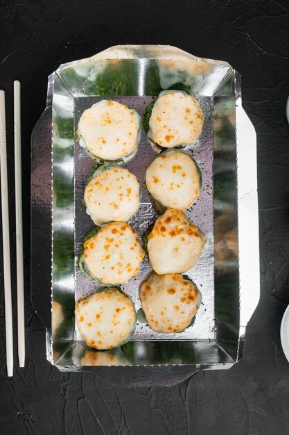 Variedade de diferentes sushis e pãezinhos, salmão e atum em conjunto de conceito de entrega de comida, na pedra preta