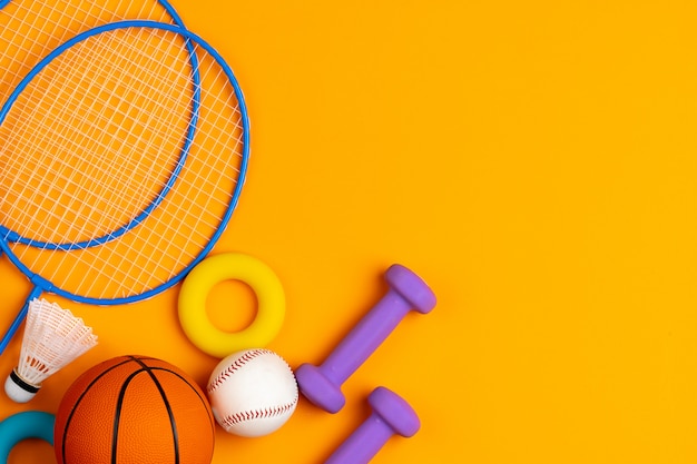 Variedade de equipamentos de esporte em fundo amarelo, vista superior