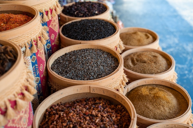 Variedade de especiarias e ervas turcas em tigelas de madeira. especiarias do mercado turco, como açafrão, sumagre e tomilho. cominho, alecrim e isot.