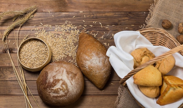 Variedade de espigas de pão e grãos de trigo na mesa de madeira Vista superior de estilo rústico