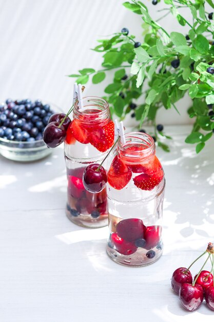 Variedade de frutas com água detox em garrafinhas de vidro. bebidas refrescantes de verão. conceito de dieta saudável.