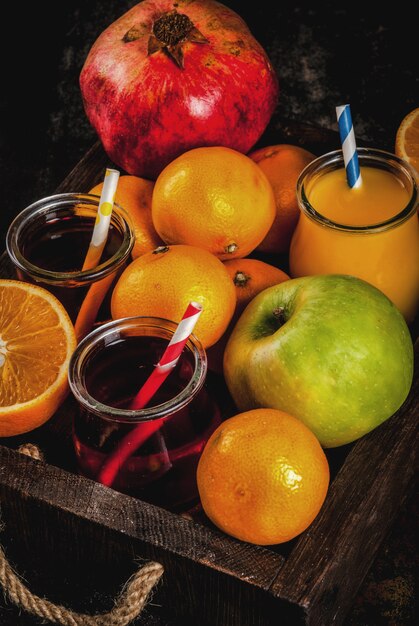 Foto variedade de frutas e sucos frescos. laranjas, romã e maçãs