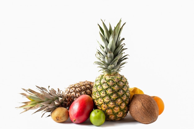 Variedade de frutas tropicais, isolada no fundo branco. abacaxi, coco, manga, laranja, limão, limão e kiwi