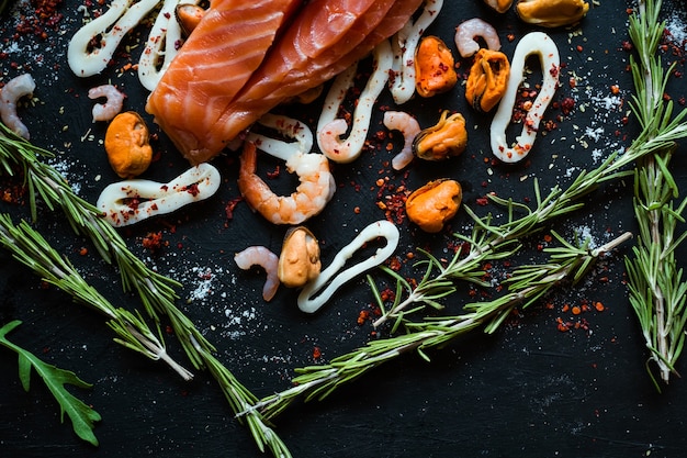 Variedade de frutos do mar e salmão em superfície escura. Gorduras insaturadas de ácido ômega 3. Alimentação saudável. Conceito de cozinha mediterrânea