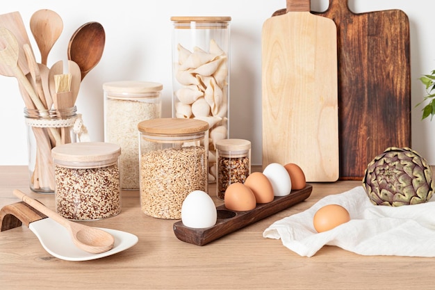 Variedade de grãos, cereais e massas em potes de vidro e utensílios de cozinha Estilo de vida sustentável