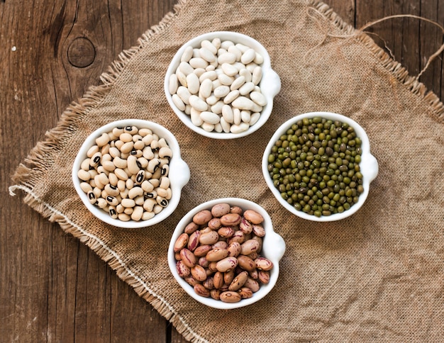 Variedade de legumes em tigelas na vista superior de mesa de madeira