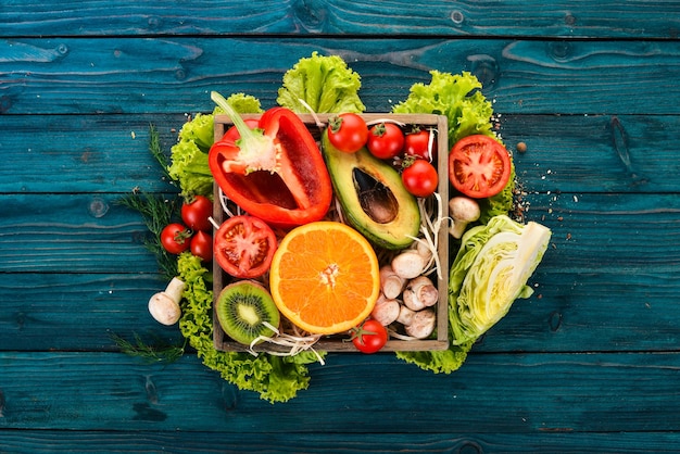 Variedade de legumes frescos e frutas Comida saudável Em um fundo azul de madeira Vista superior Copiar espaço