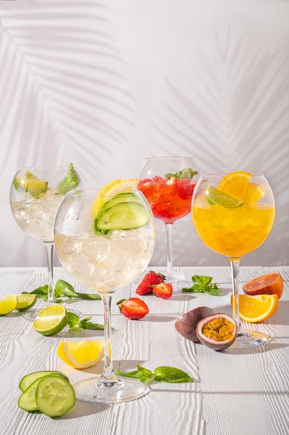 Variedade de limonadas geladas em taças de vinho na mesa de madeira no sol da manhã