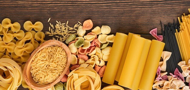 Variedade de massa tradicional italiana: espaguete colorido, tagliatelle, farfalle, penne, ptititm, macarrão, fusilli, canelone