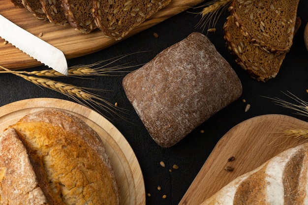 Variedade de pães em fundo preto centeio sem glúten trigo semeado grãos integrais