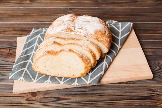 Variedade de pão fresco fatiado com guardanapo na mesa rústica vista superior pão ázimo saudável fatia de pão francês