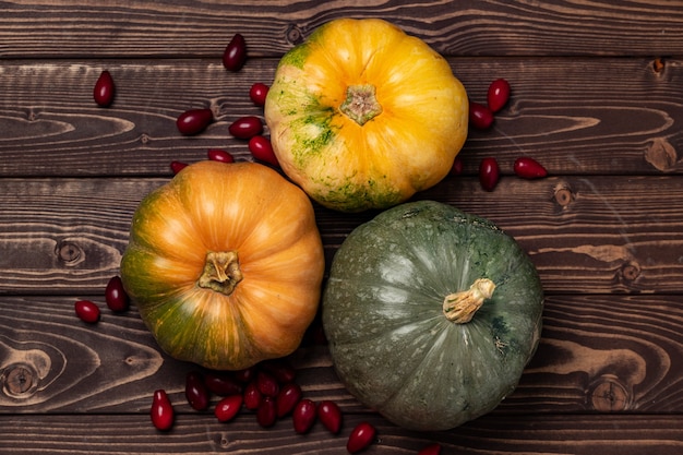 Variedade de pequenas abóboras laranja em madeira