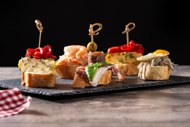 Variedade de pintxos espanhóis na mesa de madeira