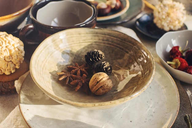 Variedade de pratos de cerâmica tigelas pratos vitrificados e talheres em foco seletivo de mesa de pedra