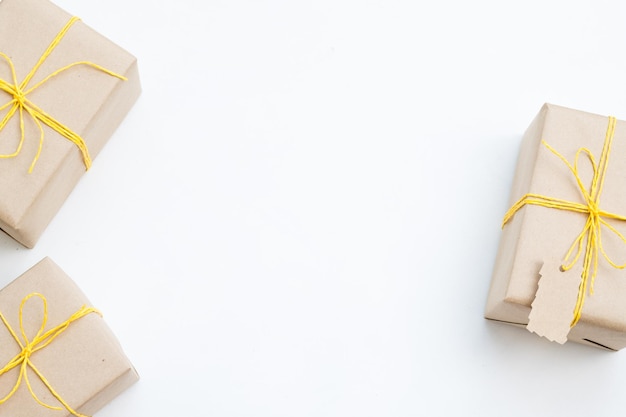 Variedade de presentes embrulhados em papel artesanal amarrados com um fio amarelo presentes de feriado no natal ou ano novo três pacotes em fundo branco com espaço livre