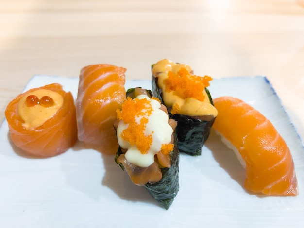 Variedade de rolos de sushi de salmão na chapa branca. conceito tradicional de comida crua japonesa