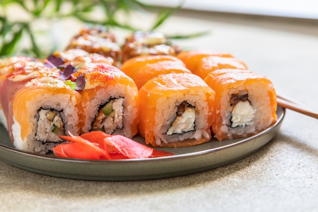 Variedade de rolos de sushi servidos com palitos de gengibre em prato de cerâmica Menu de sushi comida japonesa