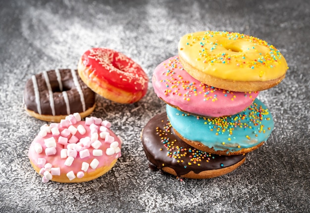 Variedade de rosquinhas coloridas na mesa escura