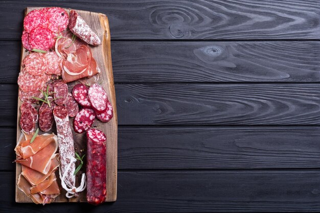 Variedade de salsichas, salame de presunto e jamon na placa de madeira