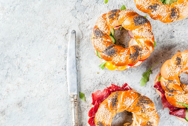 Variedade de sanduíches caseiros de bagels com carne e legumes