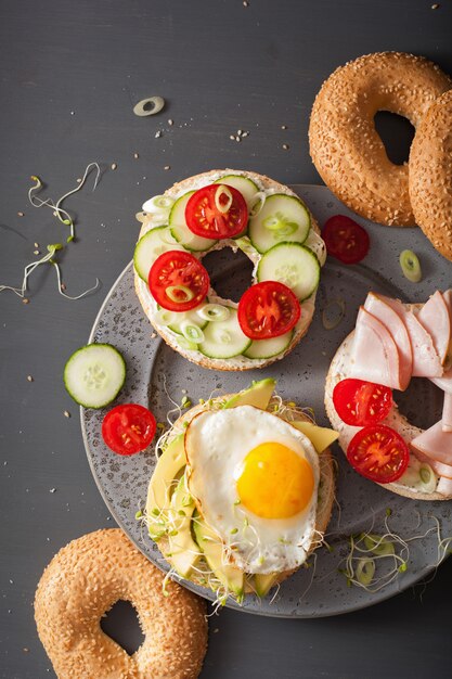 Variedade de sanduíches em bagels com ovo e legumes